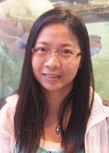 Headshot of Linying Ji with long dark hair, glasses, green and white top, and pink jacket.