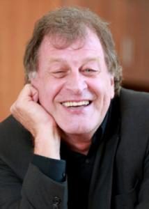 Headshot of Peter Molenaar with light brown hair, black shirt, and dark gray jacket.