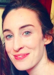 Headshot of Roisin White with long brown hair.